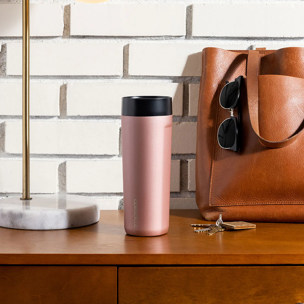 corkcicle commuter cup sitting on a table next to a lamp, keys, and a bag