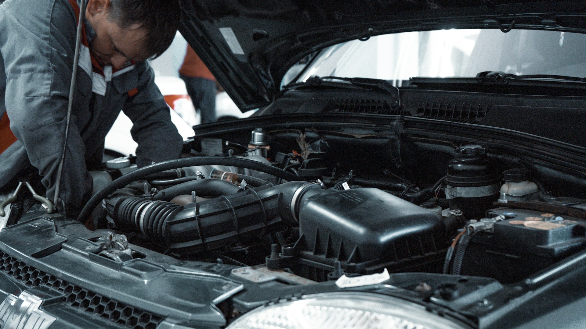 Mechanic working on a car engine in a garage