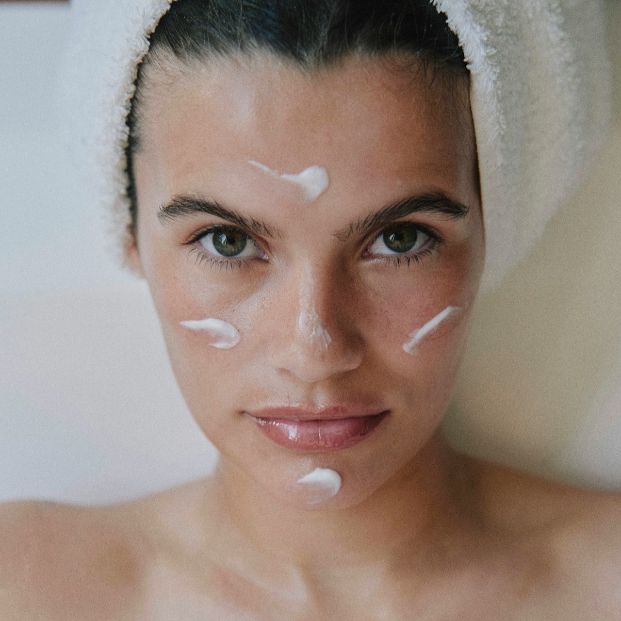 Facial Skincare Routine Woman with facial cream and towel on head