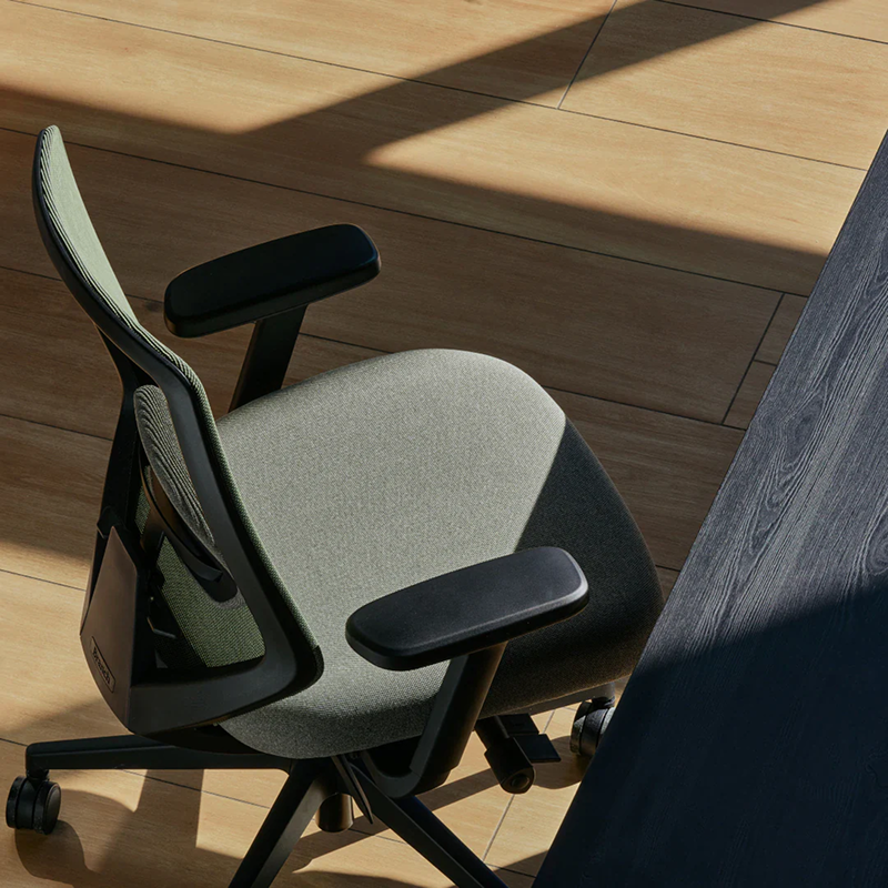 Ergonomic Office Chair in Sunlit Room Ergonomic office chair with armrests and wheels on wooden floor