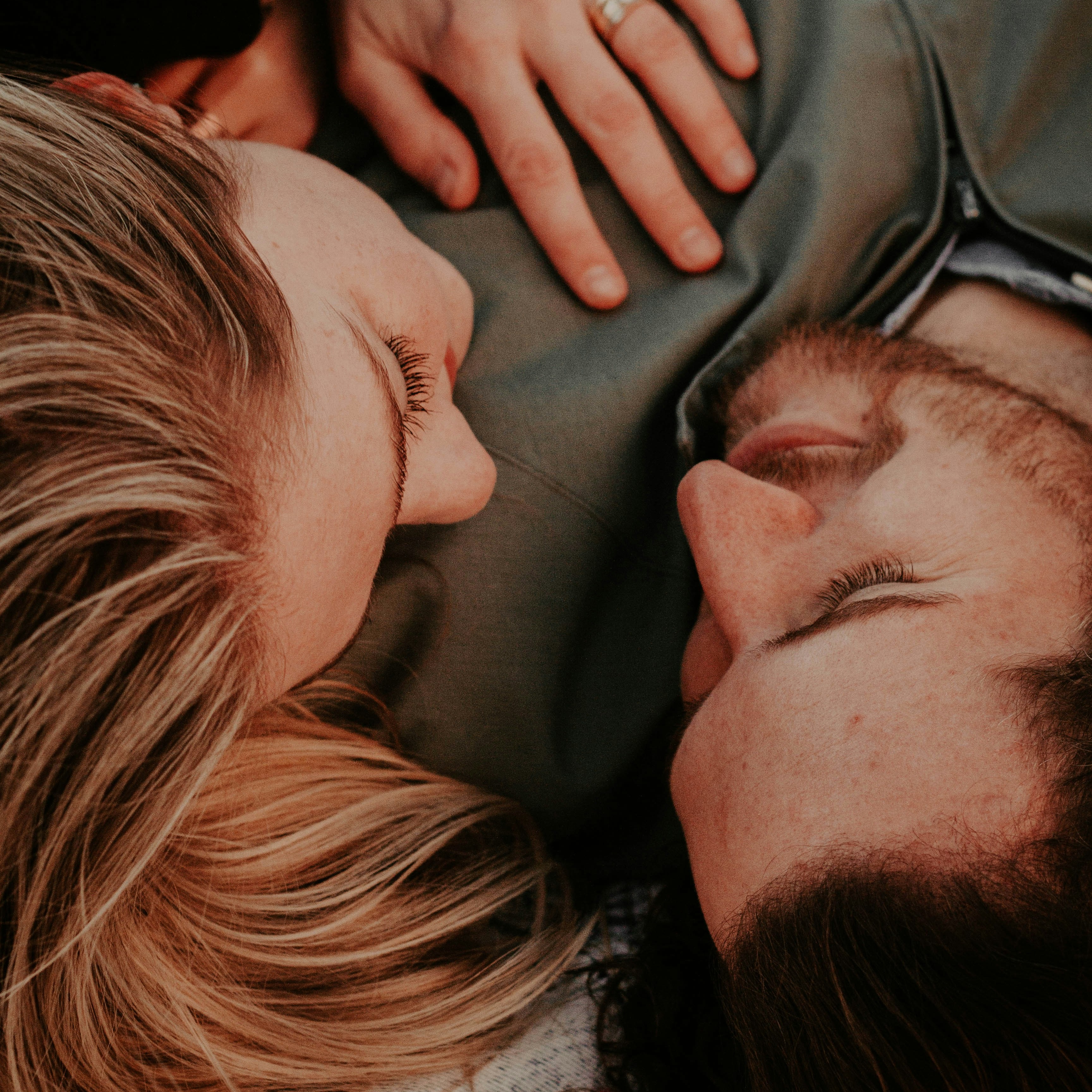 Couple Sharing an Intimate Moment Couple lying close together, woman's hand on man's chest