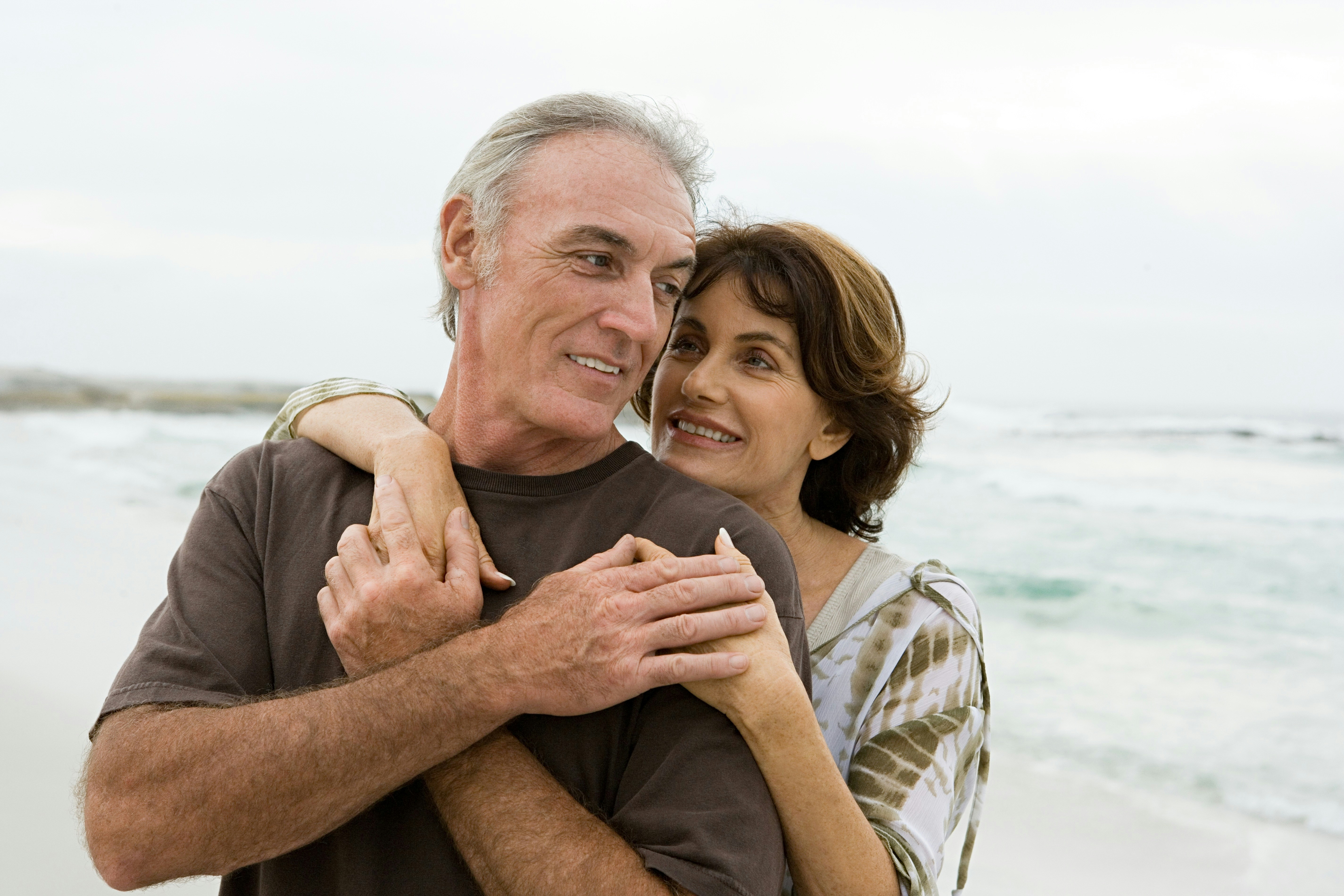 Older couple embracing on a beach