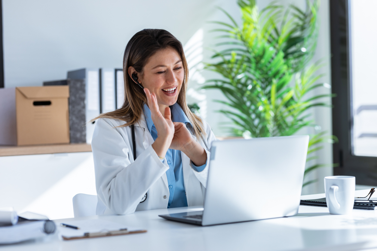 A doctor in her office waving at a laptop as she meets with a GLP-1 patient