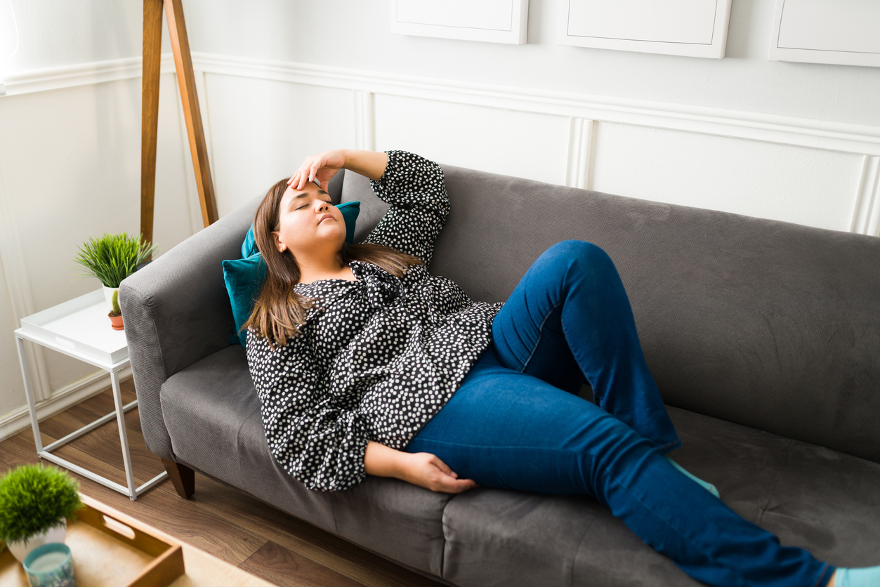 Woman lying on the couch experiencing GLP-1 side effects