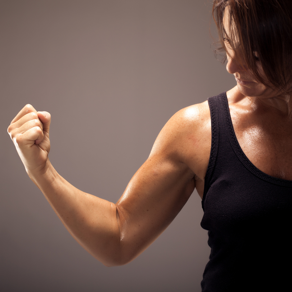 A woman flexing her arm, showing off her muscles
