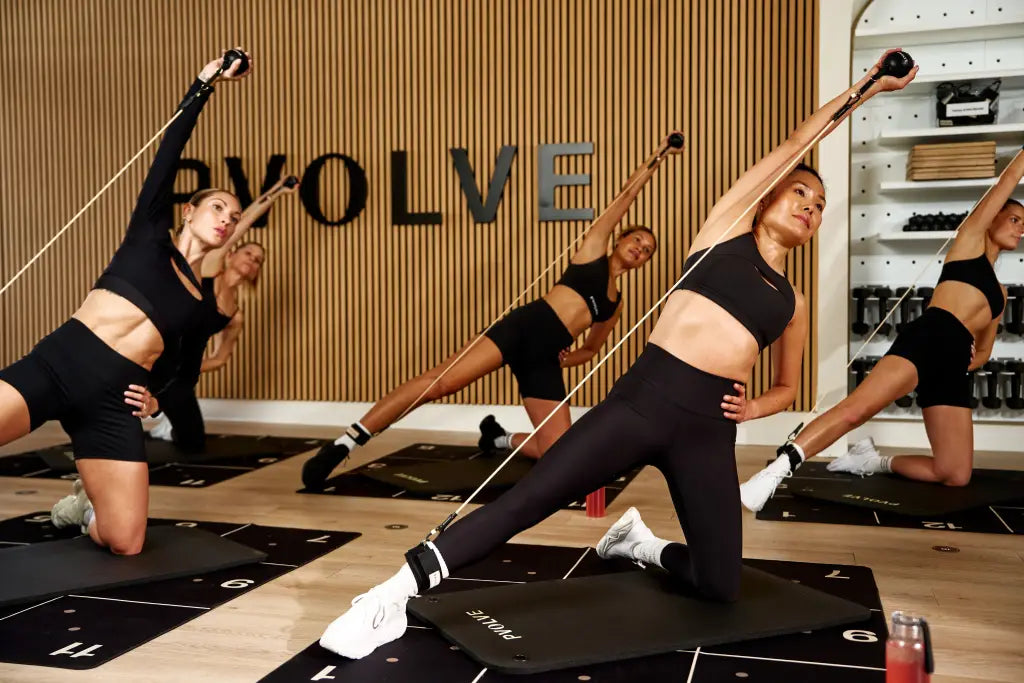 Women working out in studio, following the PVOLVE program