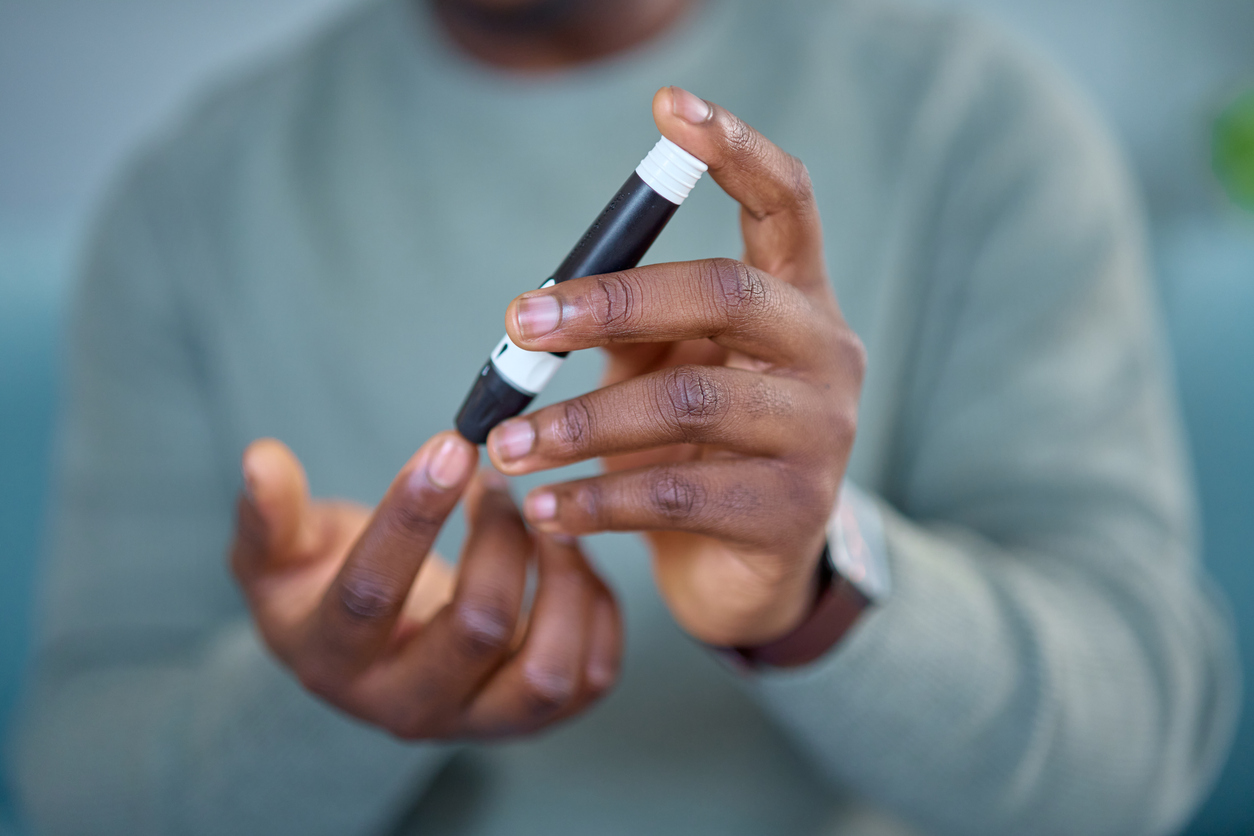A close-up of a man performing a diabetes glucose test at home