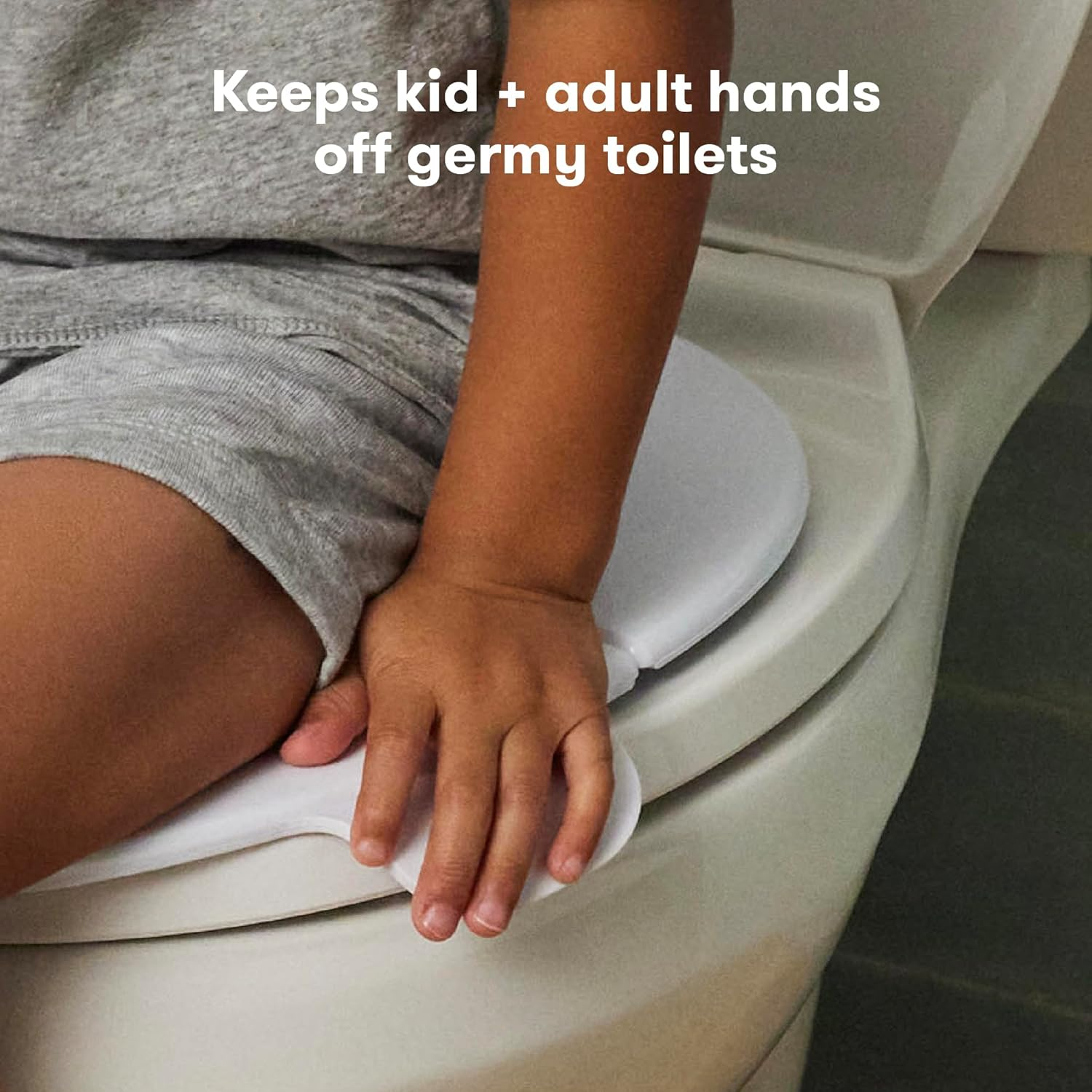 Child sitting on the Fold-And-Go Potty Seat, placing their hands on the grips