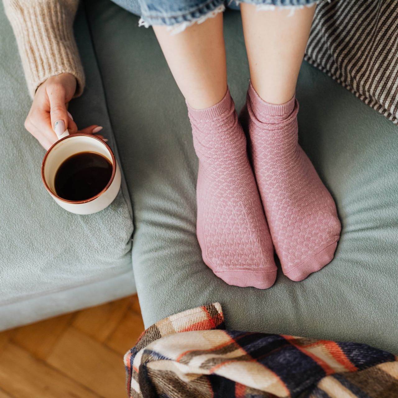 Relaxing with Coffee on the Couch Person wearing pink socks relaxes on a couch with a cup of coffee