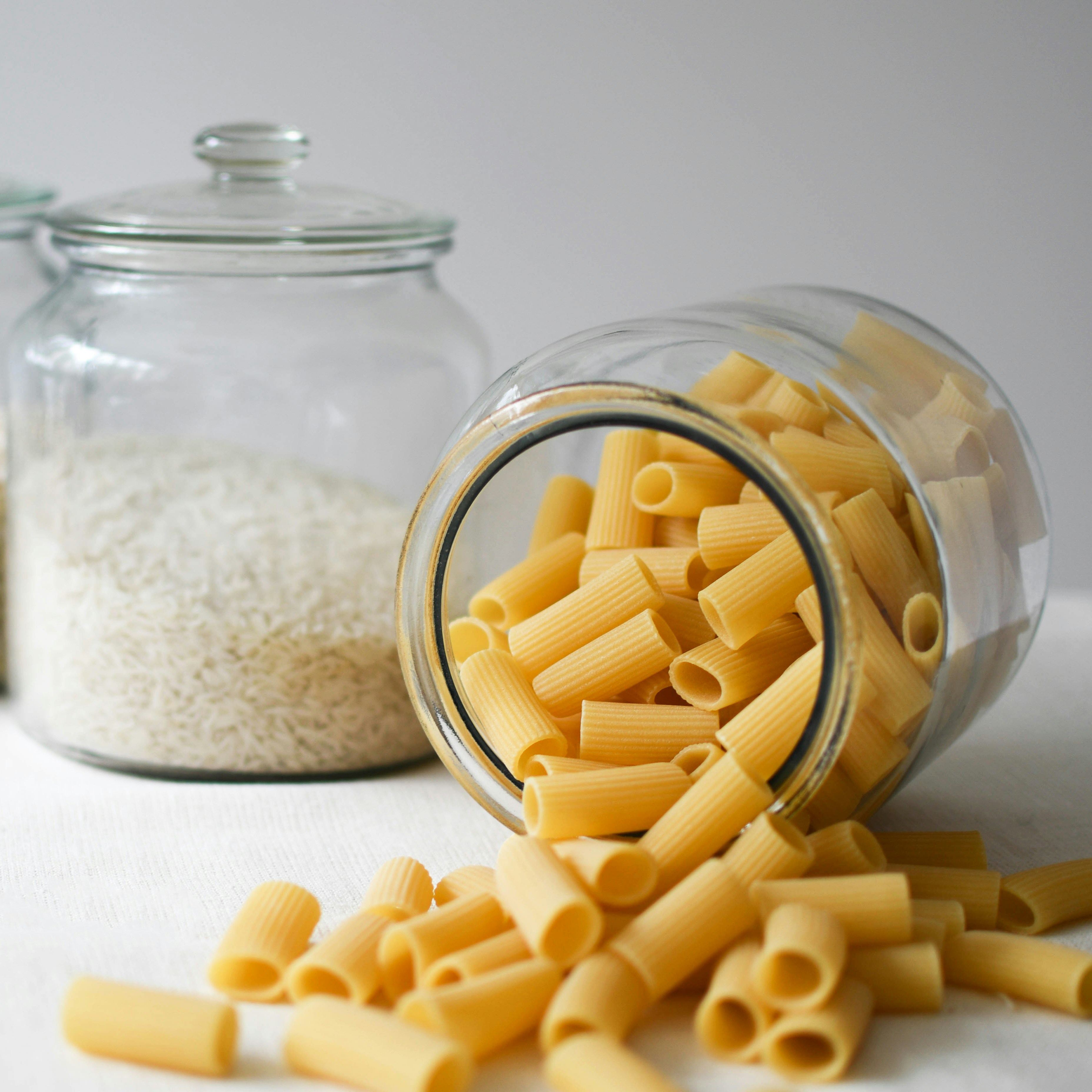 Essential Pantry Staples: Pasta and Rice Glass jars filled with pasta and rice highlight essential pantry staples