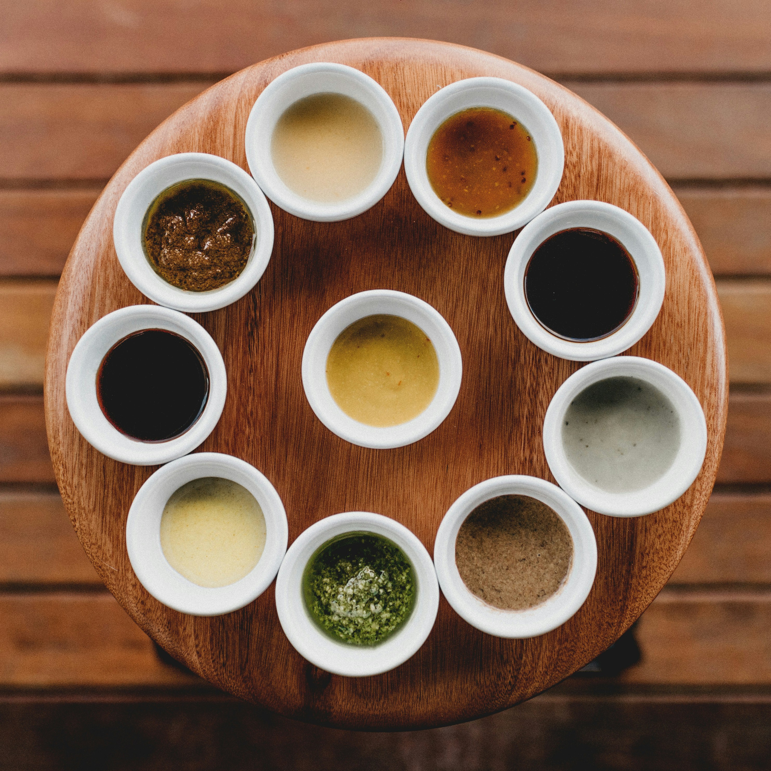 Assorted Sauces and Condiments Various sauces and condiments in small white bowls arranged in a circle