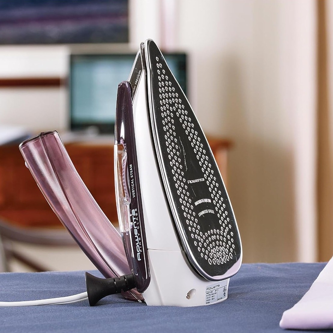 Rowenta iron stands upright on an ironing board