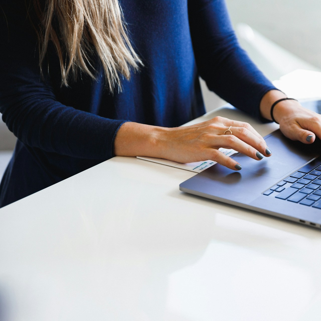 A person works on a laptop in a home office.