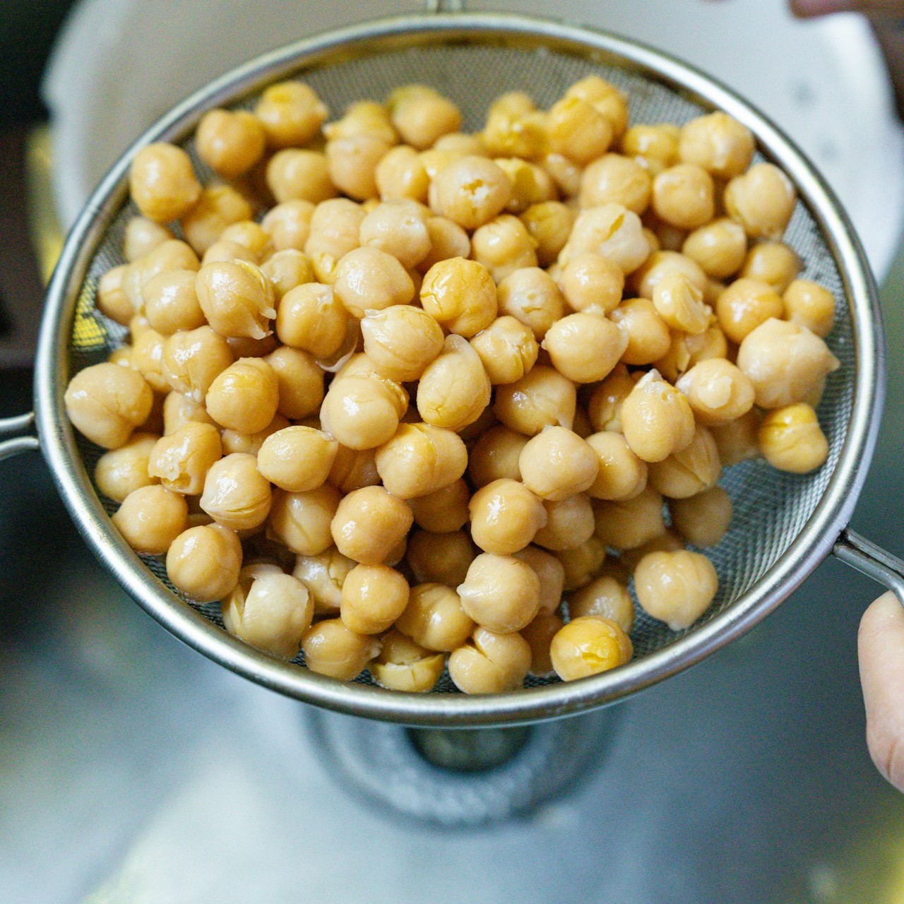 Rinsing Chickpeas Chickpeas are rinsed in a strainer, ready for use in various recipes