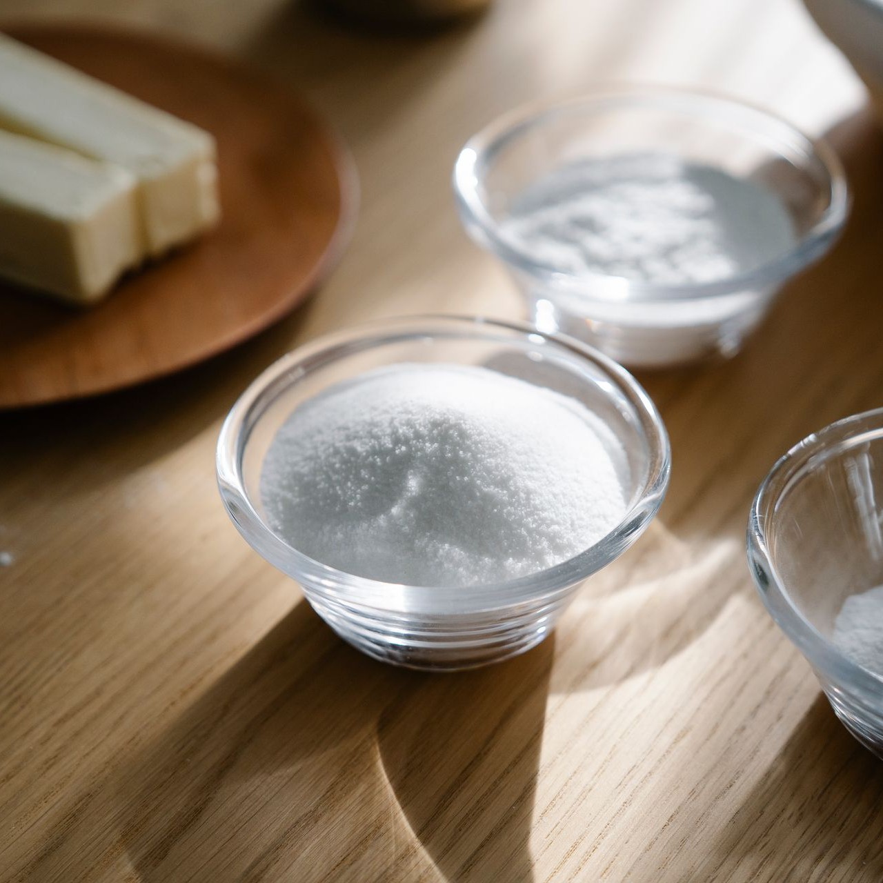 Mise en Place Ingredients Small glass bowls with sugar and flour on a wooden table, showing mise en place