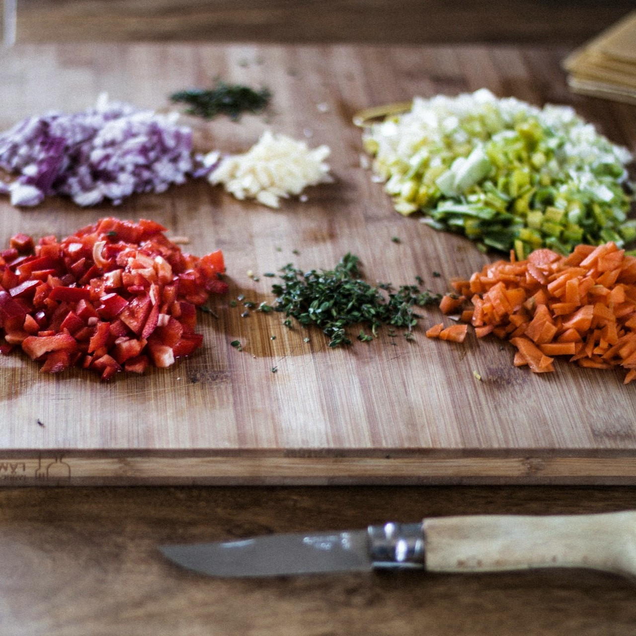 Chopped Ingredients on Cutting Board Chopped vegetables and herbs arranged on a wooden cutting board