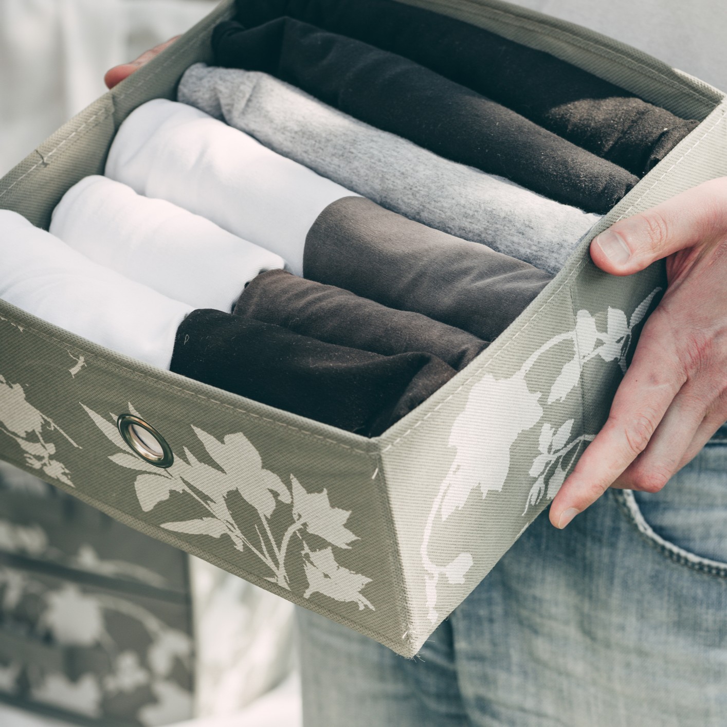 Organized Underwear Storage Box Person holds a storage box filled with neatly rolled underwear