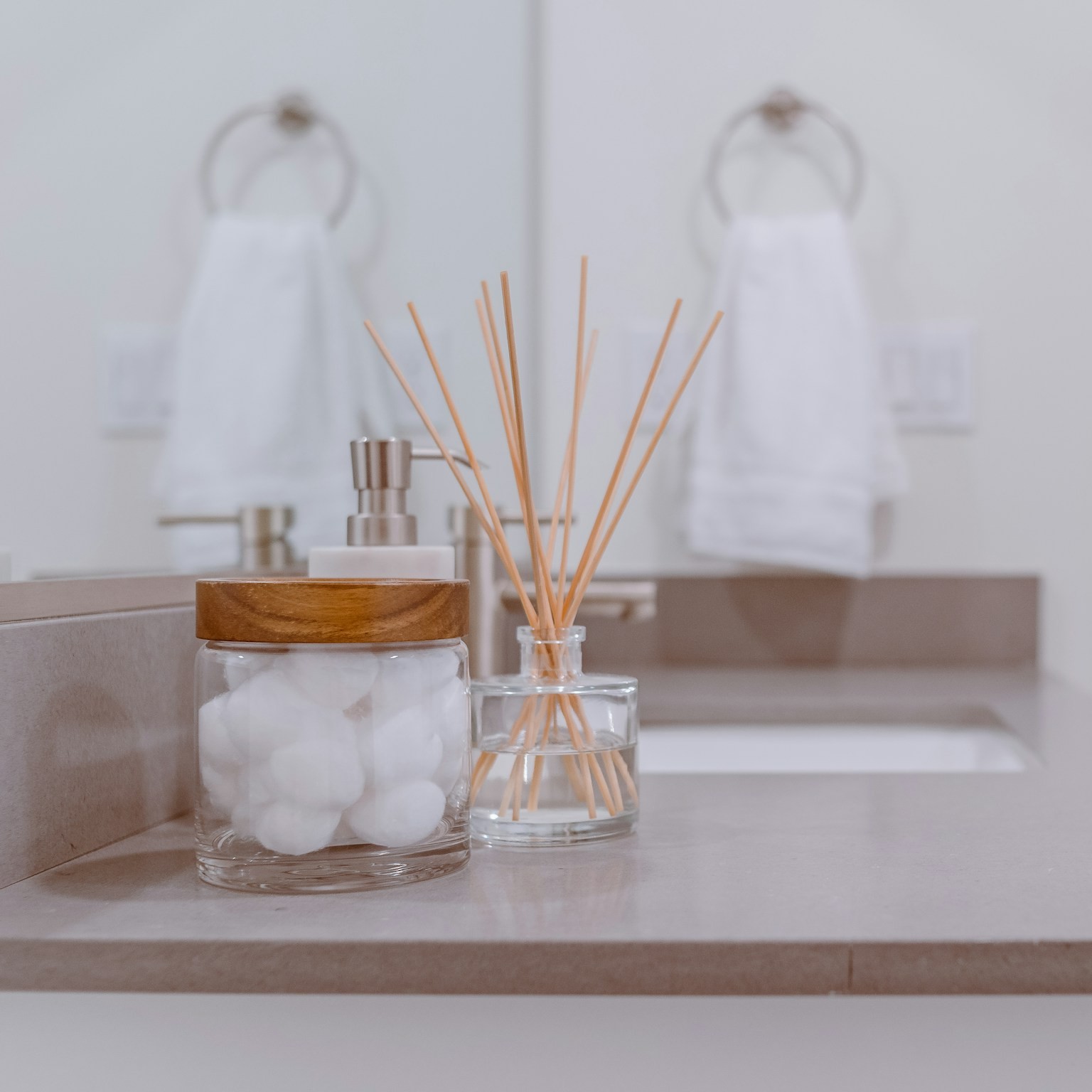 Bathroom counter with cotton balls and a reed diffuser