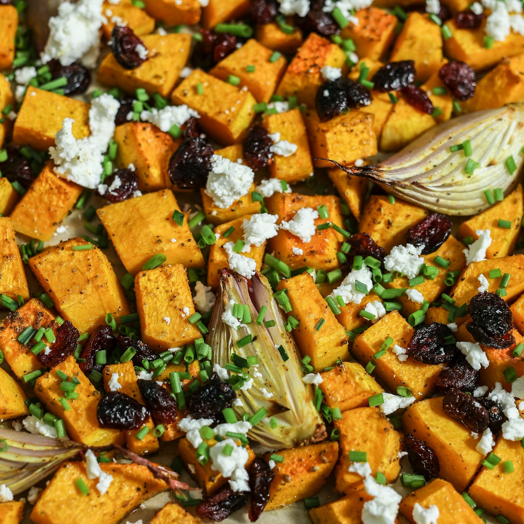 Roasted butternut squash with cranberries, feta, and chives on a tray