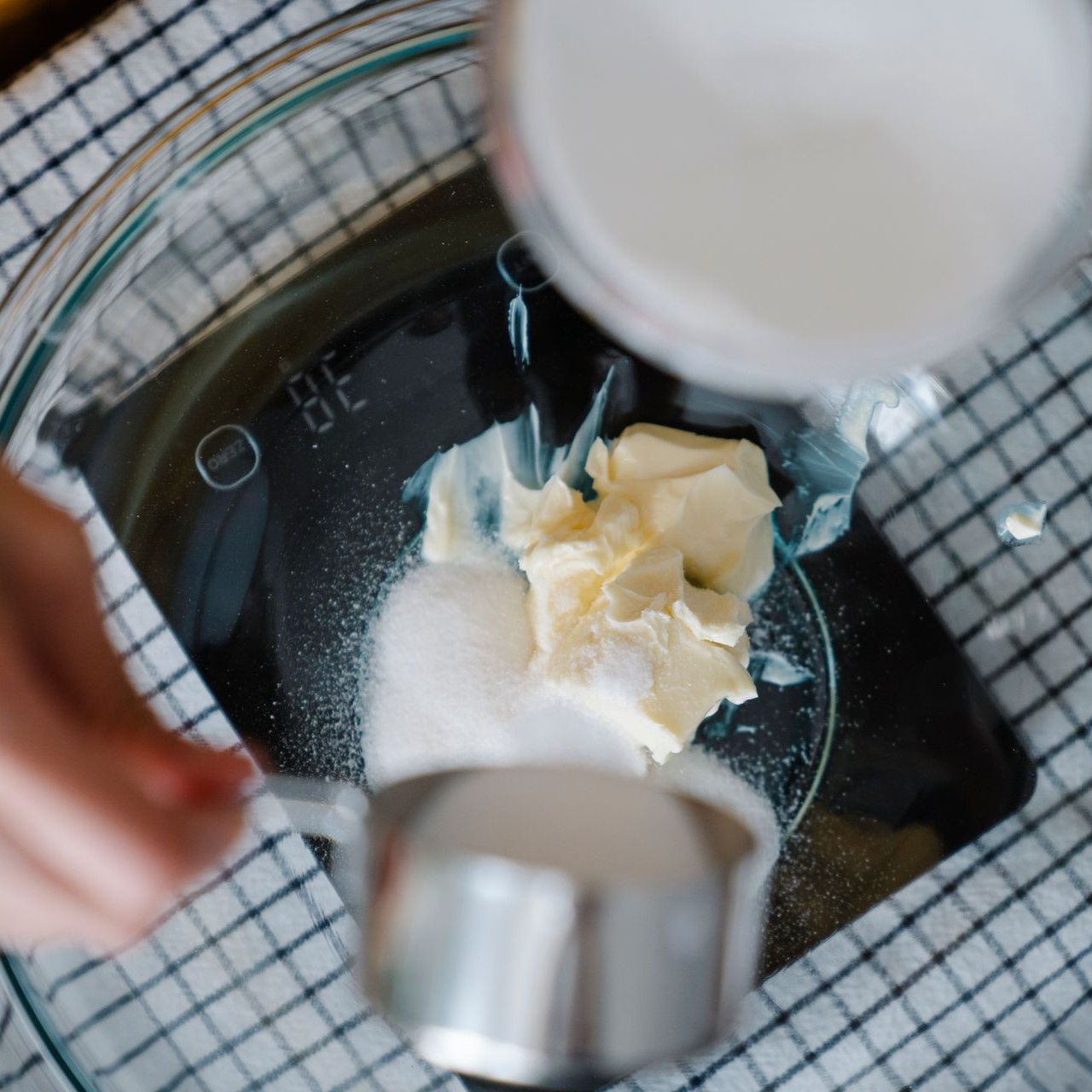 Measuring Ingredients for Baking Butter and sugar are being measured in a glass bowl on a digital scale