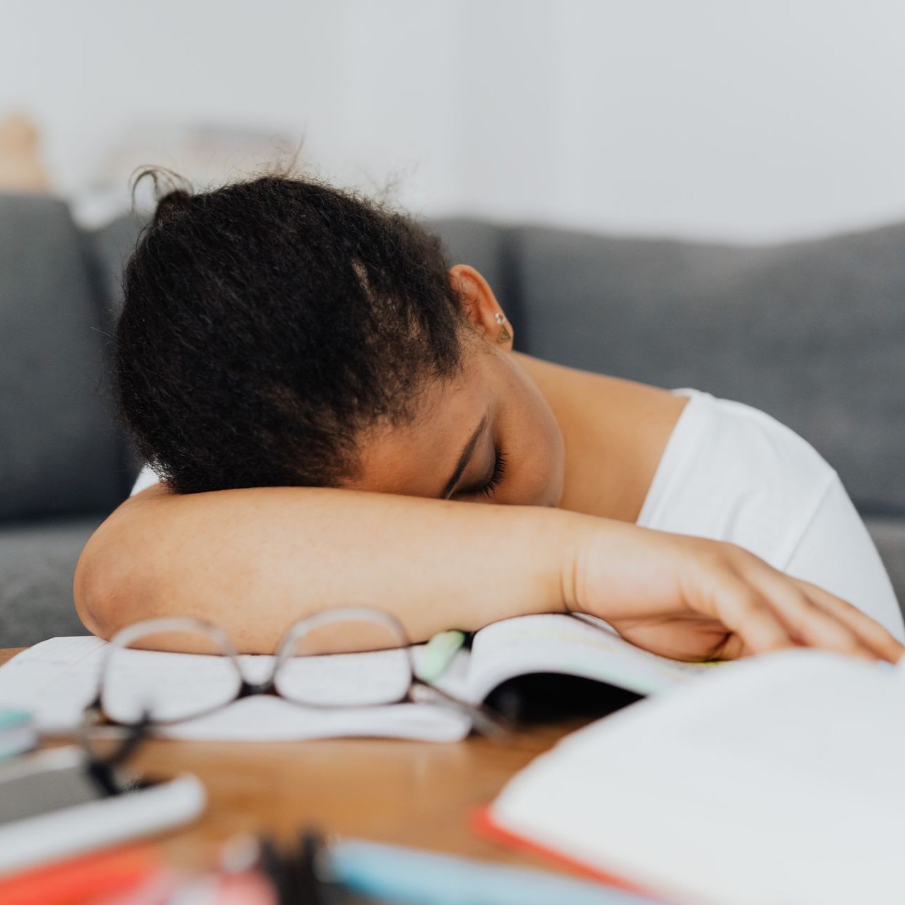 Tired Student Resting on Book A student rests their head on an open book, appearing tired