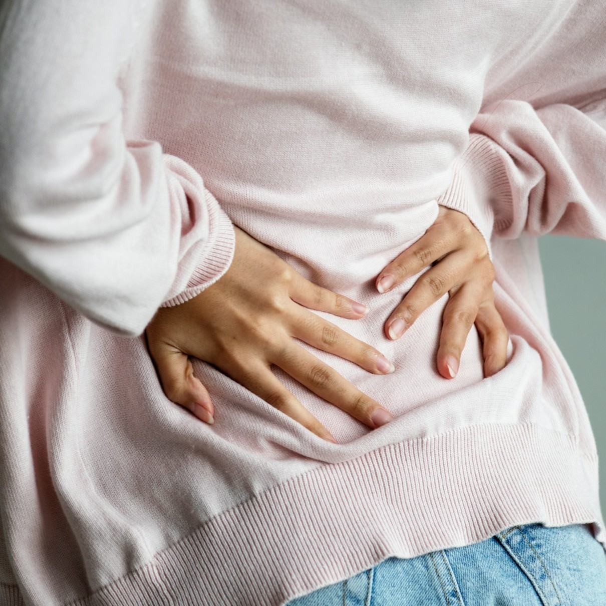 Lower Back Pain Woman holds her lower back, indicating pain