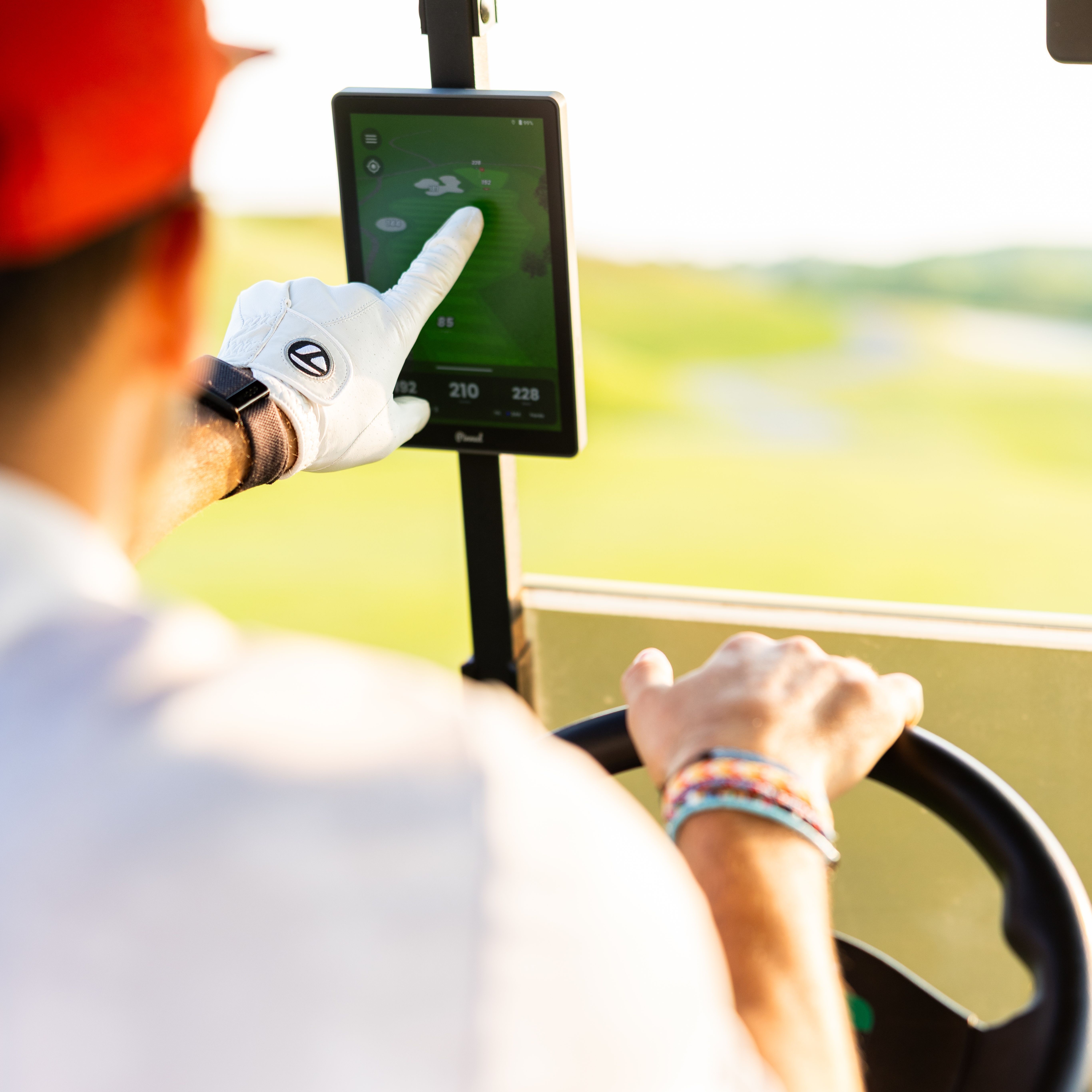A golfer uses The Caddie, which is mounted on a golf cart, to view course details