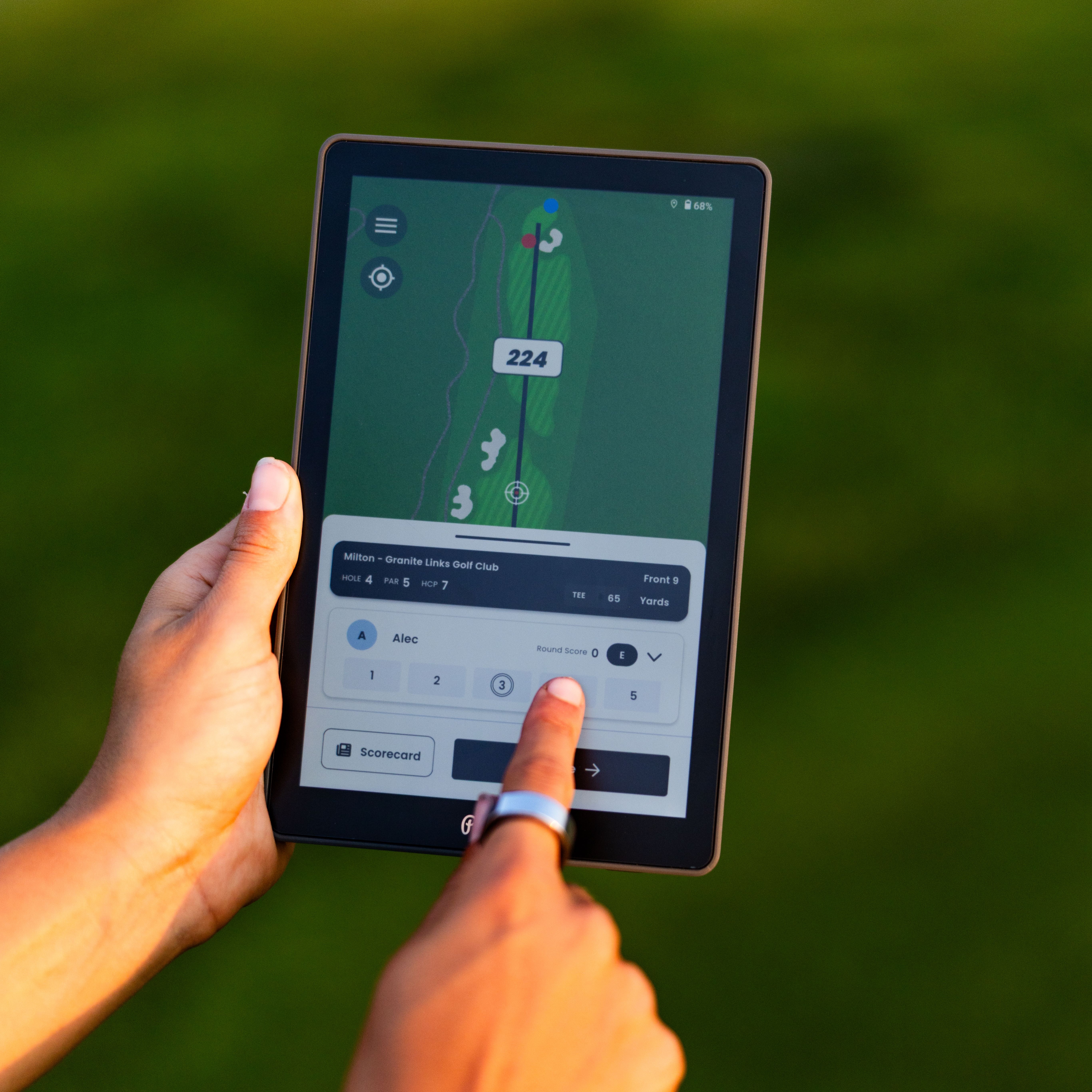 A golfer uses The Caddie tablet, which displays a golf course map with yardage details