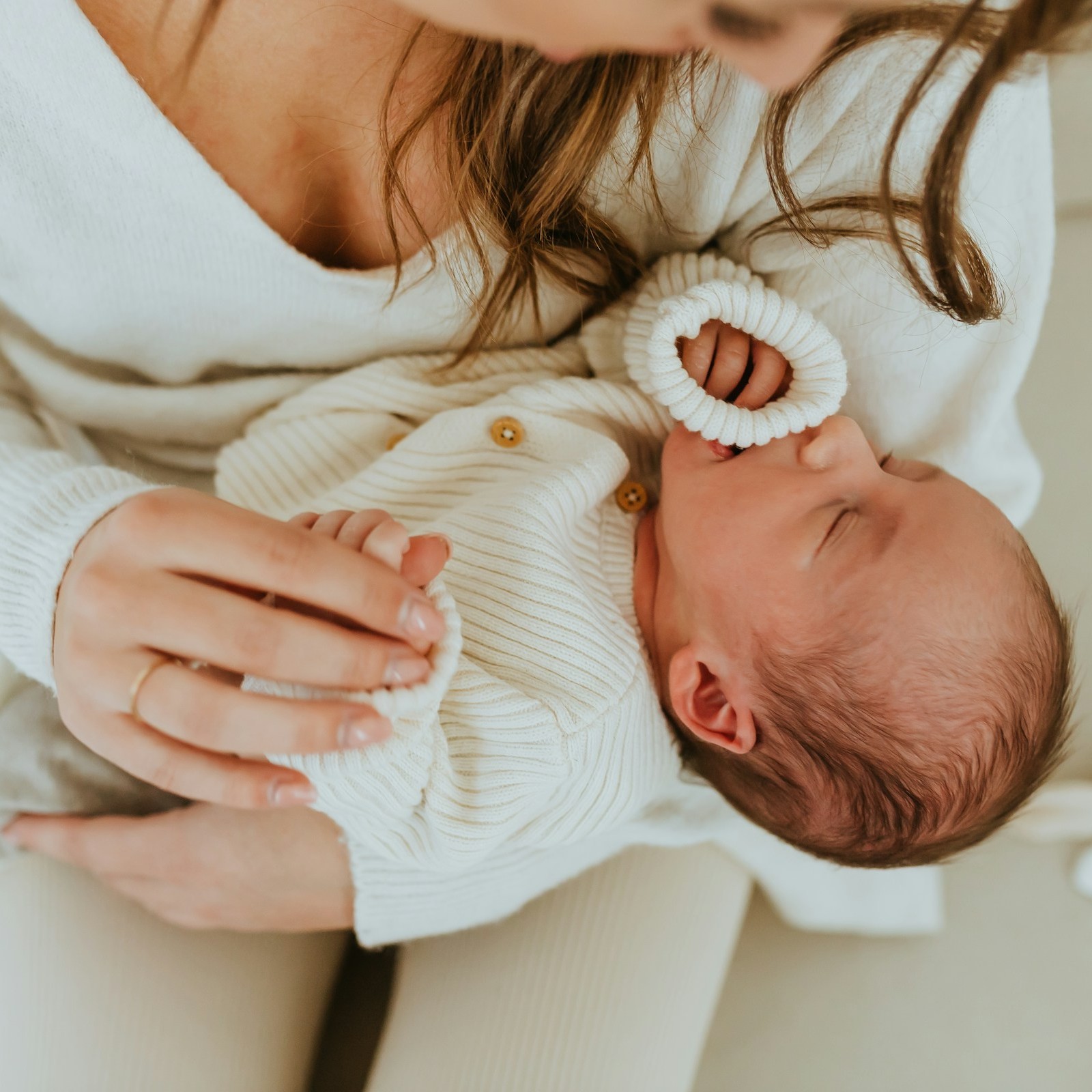 Mother Holding Newborn Baby A mother gently cradles her newborn baby in her arms.